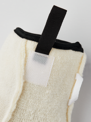 Off-white wool glove liner with black strap and stitched pocket detail