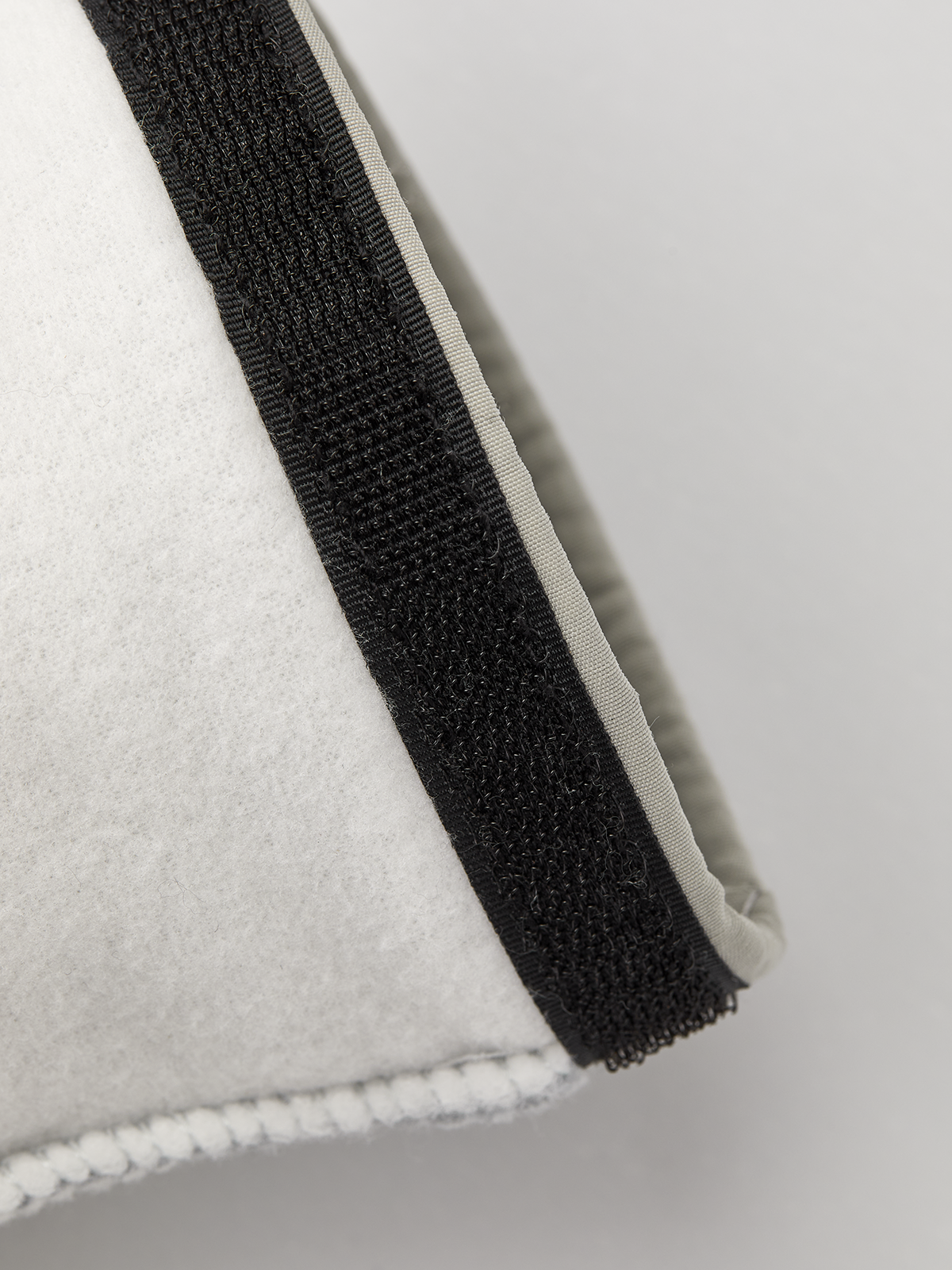 Off-white ski glove liner with black elastic wrist strap for secure fit