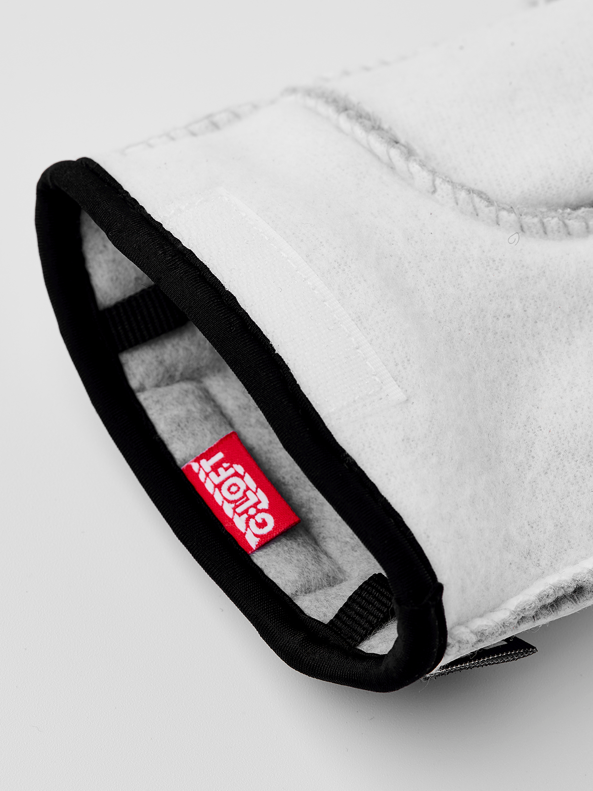 Off-white glove liner with black edge trim and red logo patch on palm