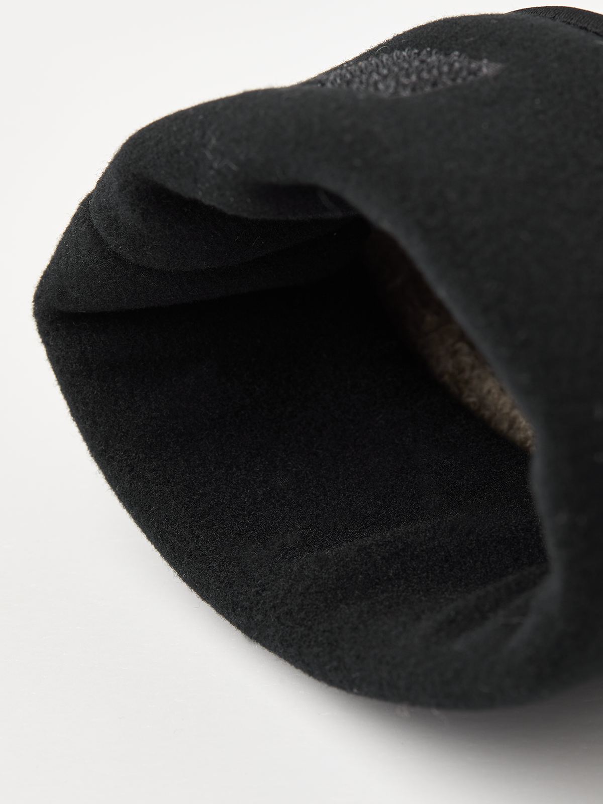 Rolled black cuff edge of beige merino knit glove liner
