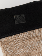 Black cuff detail on beige knit glove liner with woven logo patch