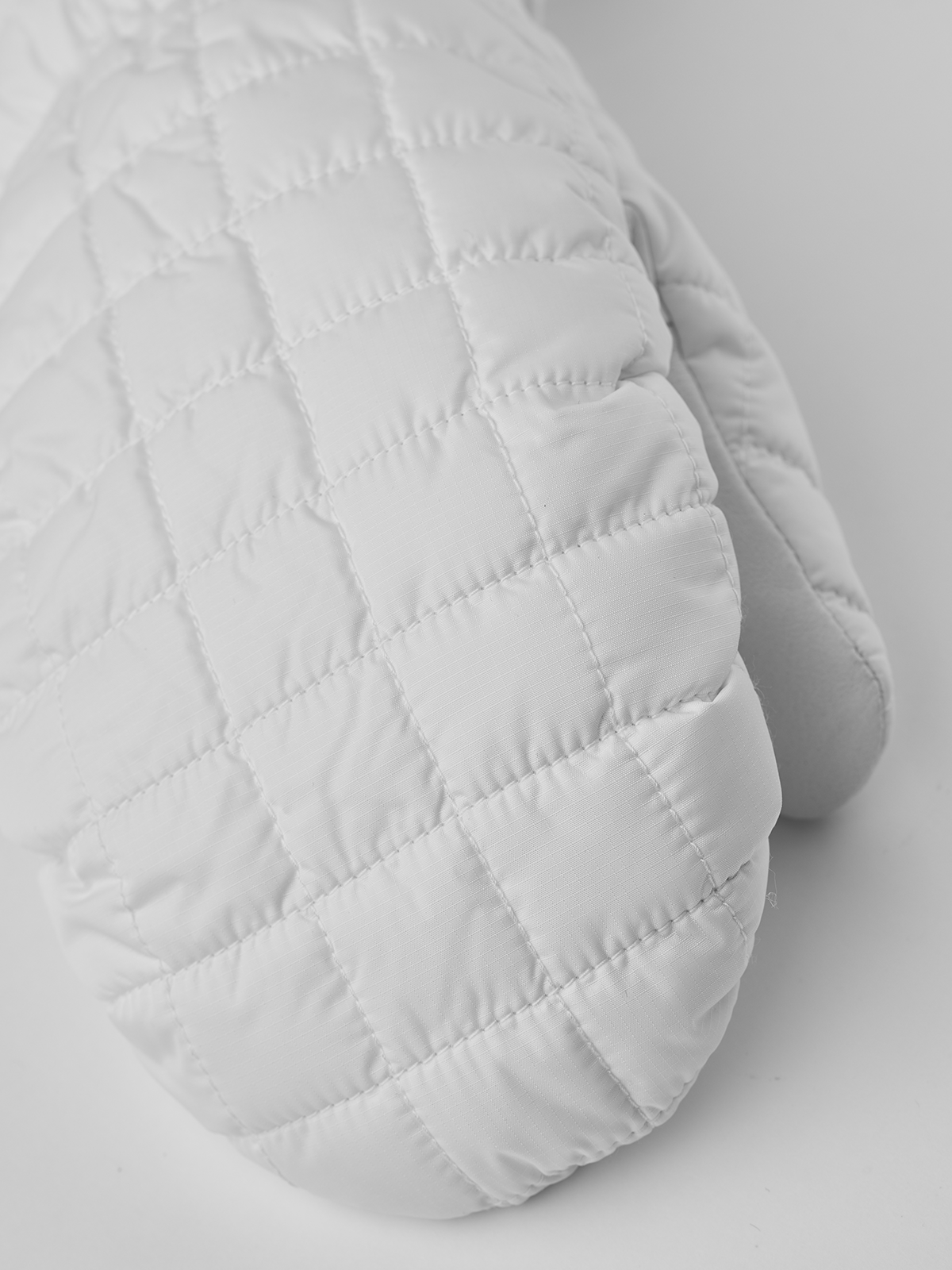 White quilted mitten with padded thumb and smooth wrist cuff seam