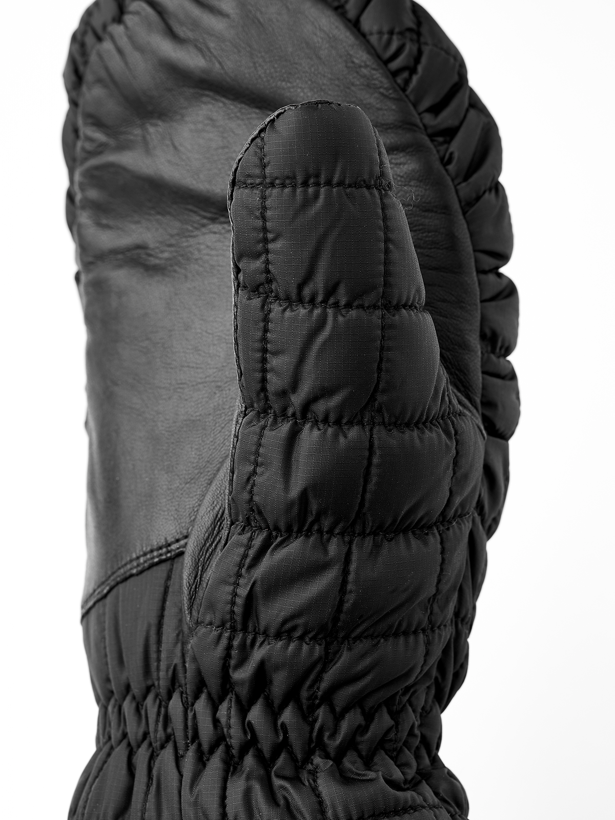 Dark quilted mitten with padded palm, stitched panels, and ribbed cuff edge