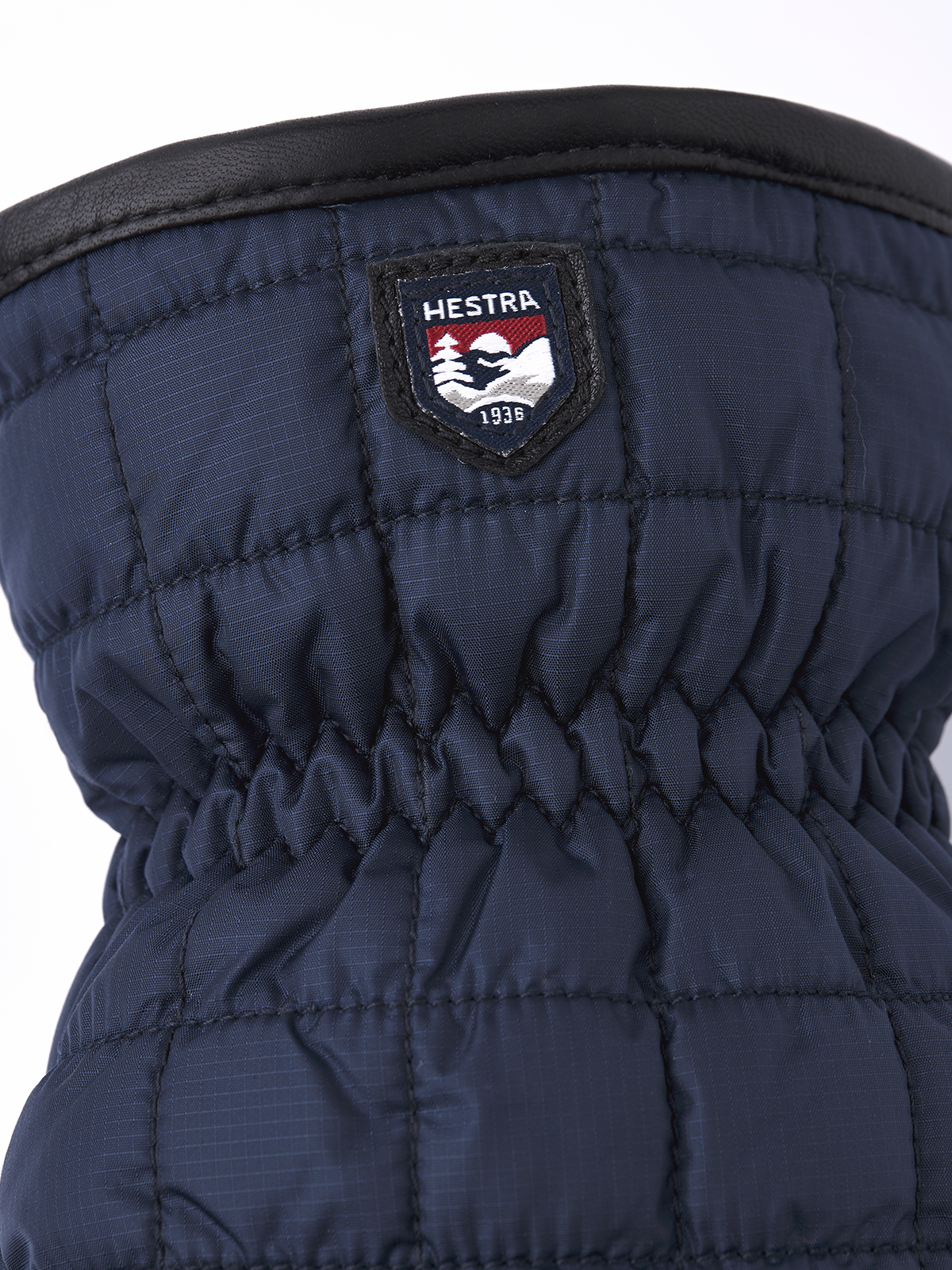 Navy mitten with Hestra logo patch on cuff and quilted palm panel stitching
