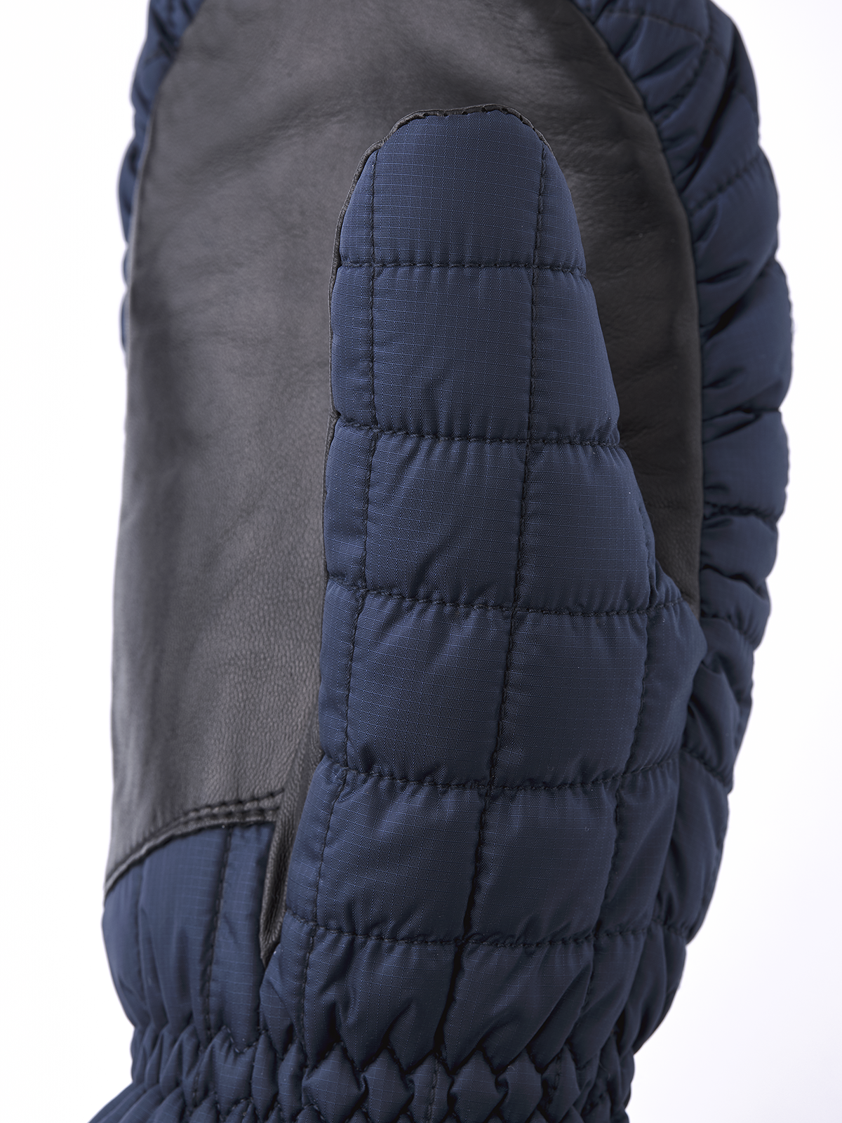 Blue mitten with quilted padding and gathered cuff at wrist opening