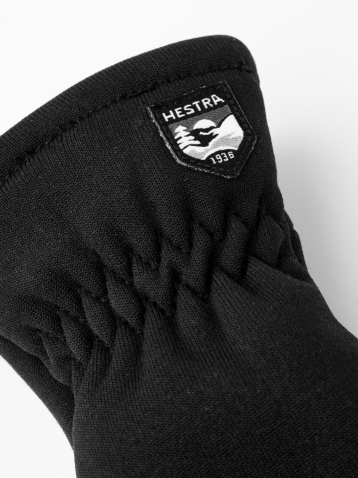Kids fleece mitten liners, black, with Hestra logo patch at wrist