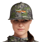Women's green camo trucker hat with black mesh back, orange animal graphic, model front
