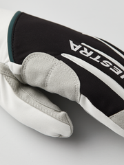 Black and off-white glove close-up with gray suede fingertips and Hestra branding
