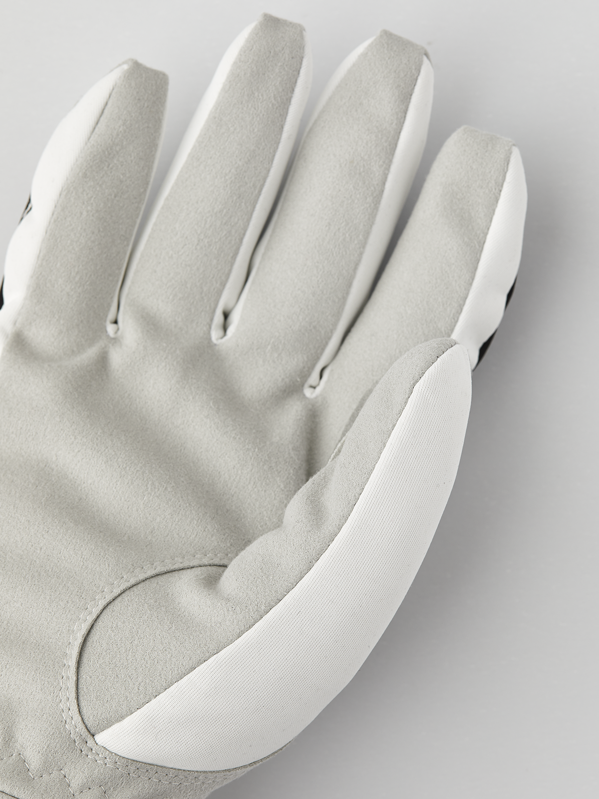 Light gray winter gloves with off-white palm panel and stitched finger seams