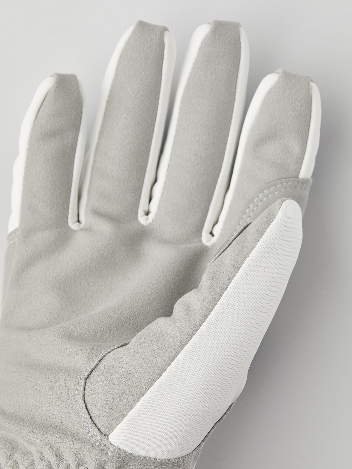 Light gray suede-and-fleece gloves with stitched fingers and curved thumb panel
