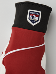 Red and off-white winter gloves with black cuff panel and Hestra shield patch