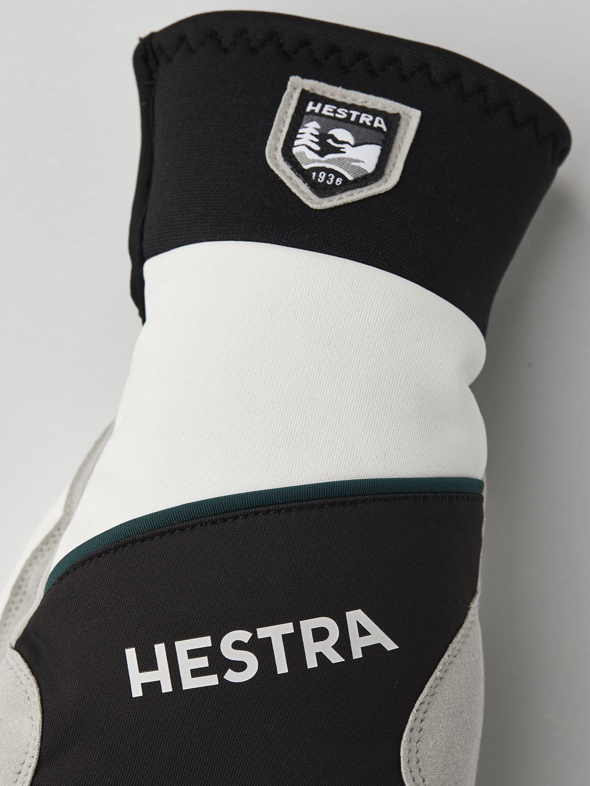 Hestra comfort tracker mittens in black and off-white with green trim stripe