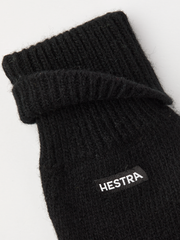Black knit glove liner with Hestra logo patch and ribbed cuff