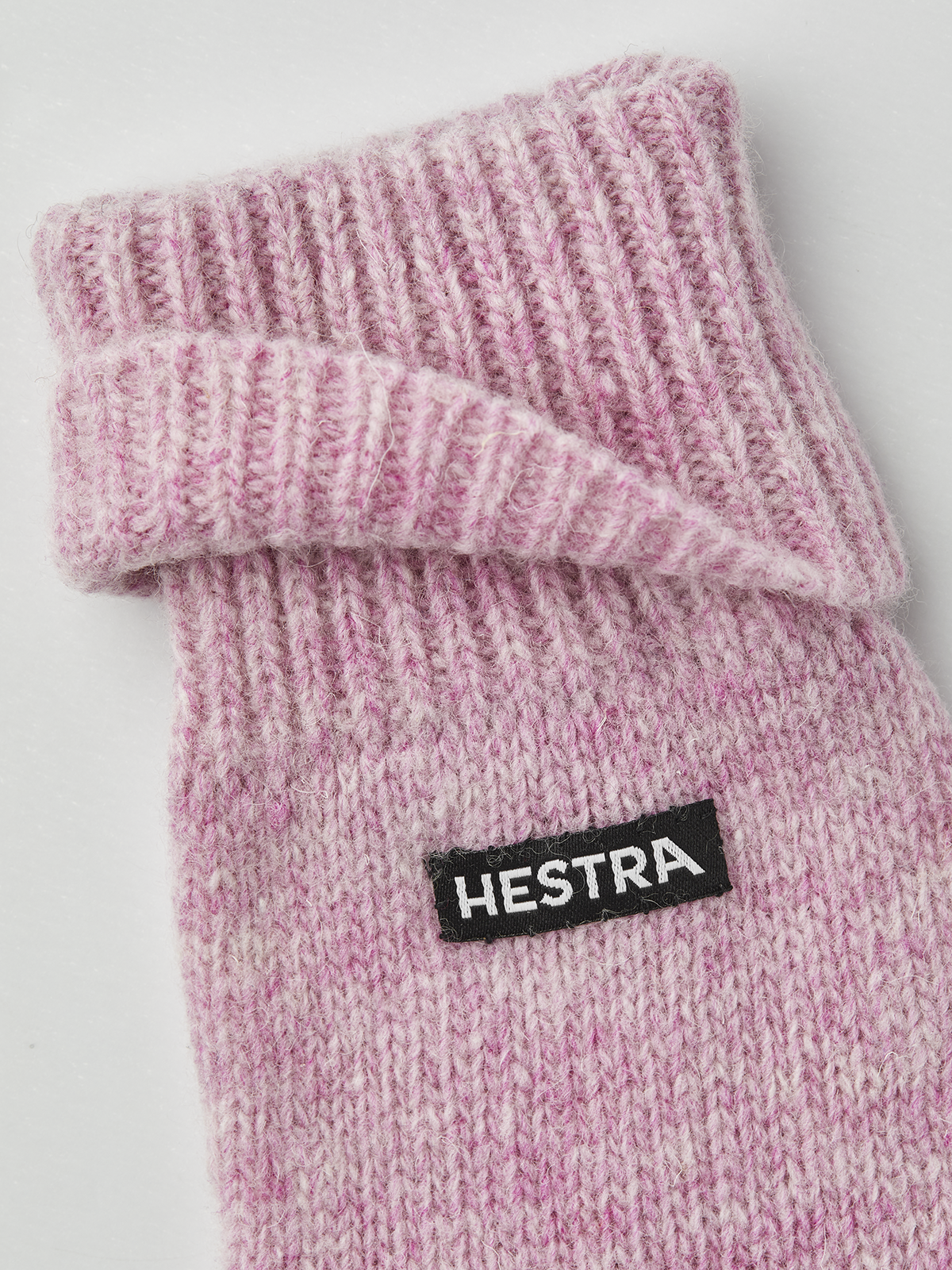 Pink knit glove liner with Hestra logo patch and ribbed knit texture