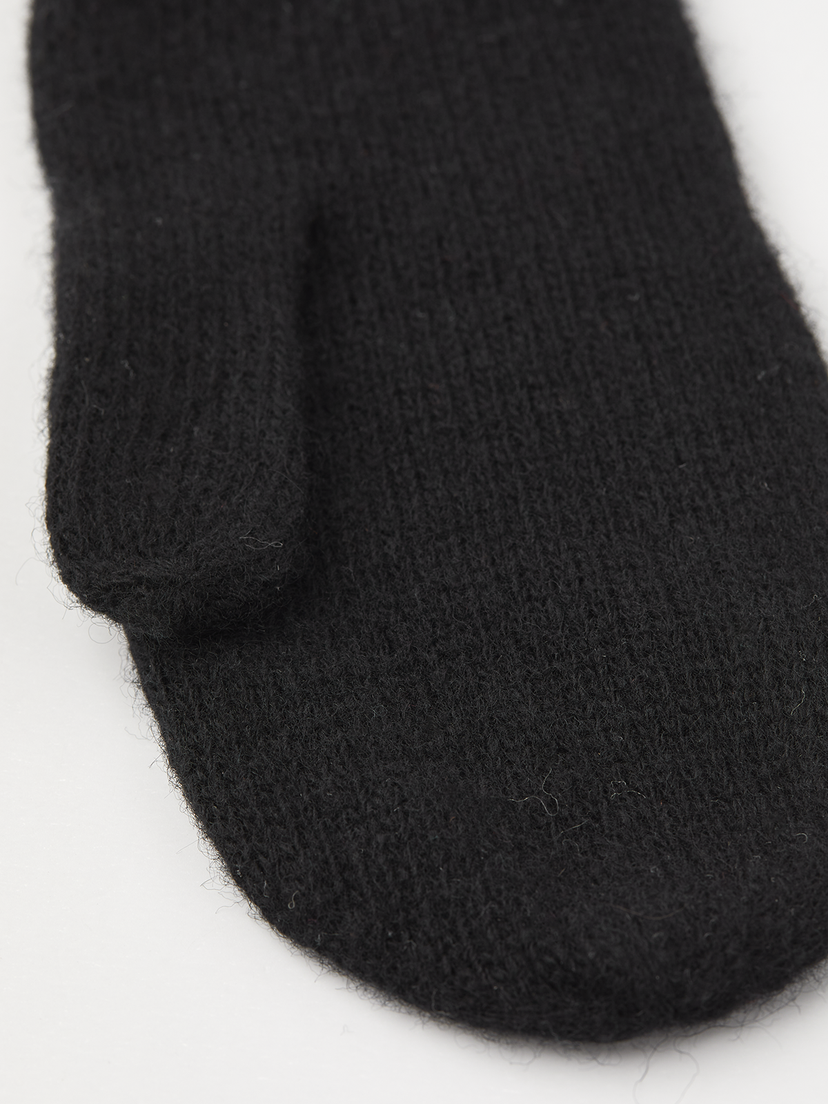 Black knit mitten liner with ribbed cuff, close-up.