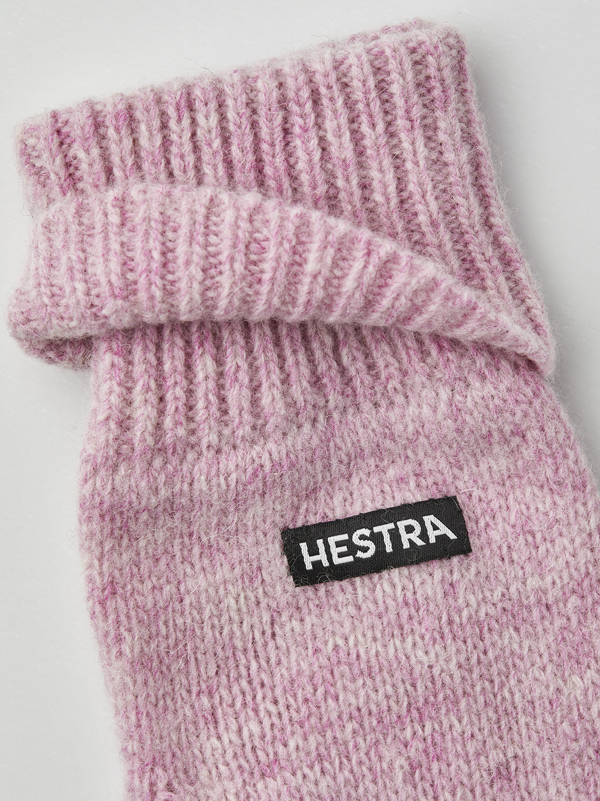 Pink knit mitten liner with ribbed cuff and HESTRA logo patch.