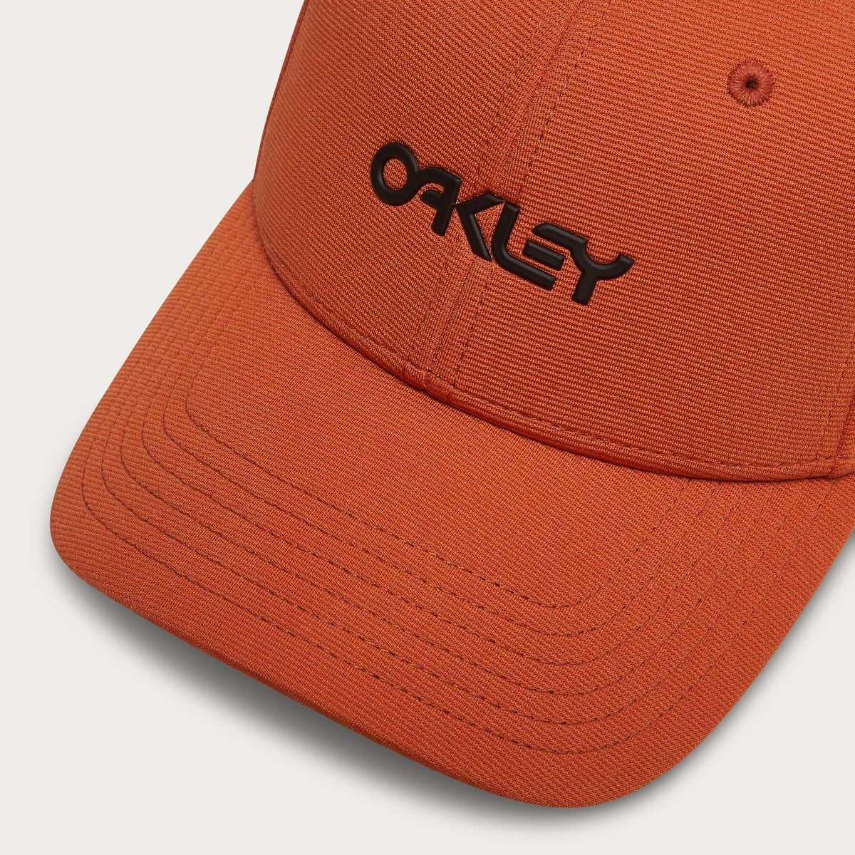 Orange stretch cap close-up with Oakley lettering on front panel