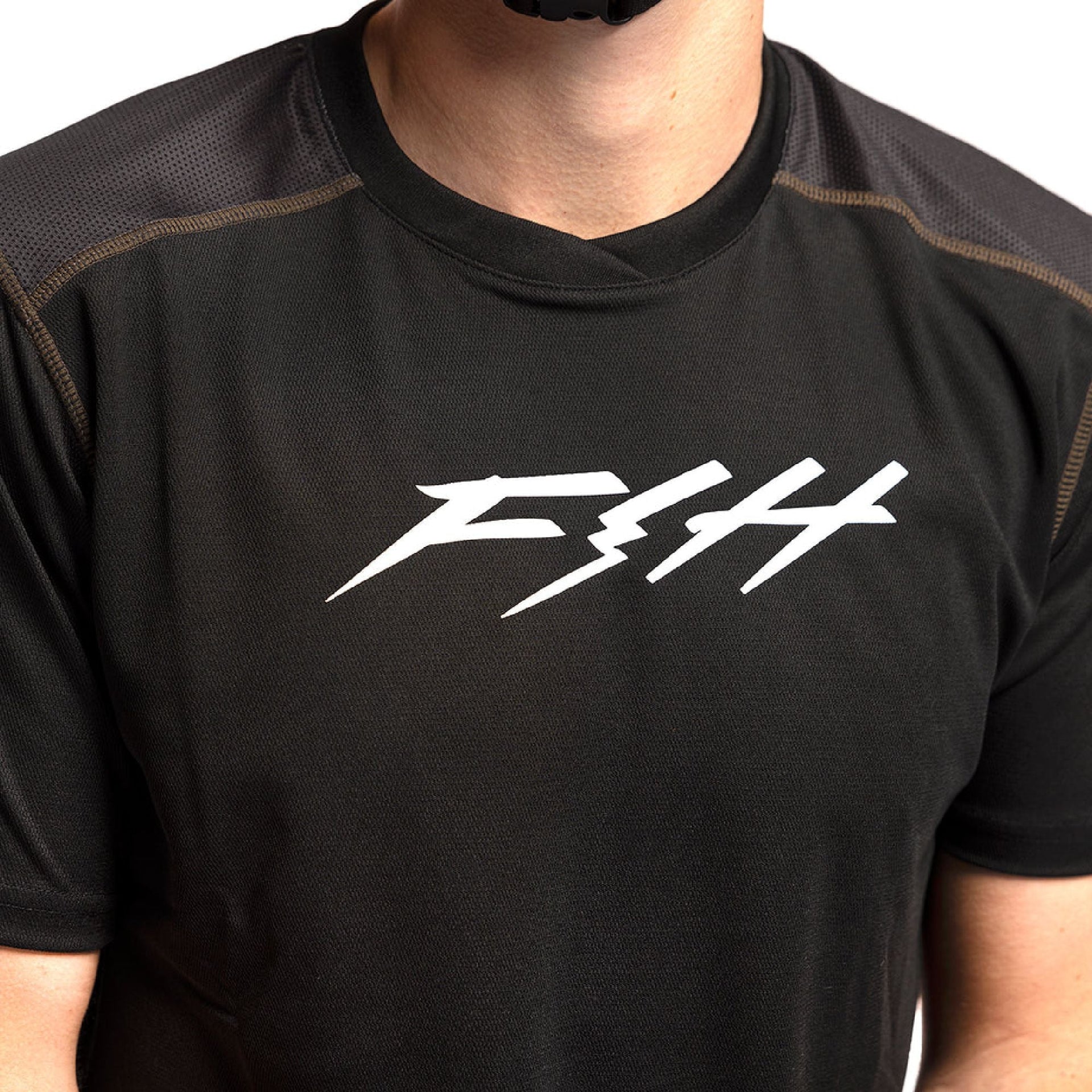Black short-sleeve jersey close-up with white FTH logo and contrast seam edging