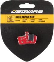 Jagwire semi-metallic disc brake pad on retail card with red backing and gray friction face
