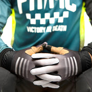 Youth motocross gloves on rider, gray palms with white stripes and black cuffs