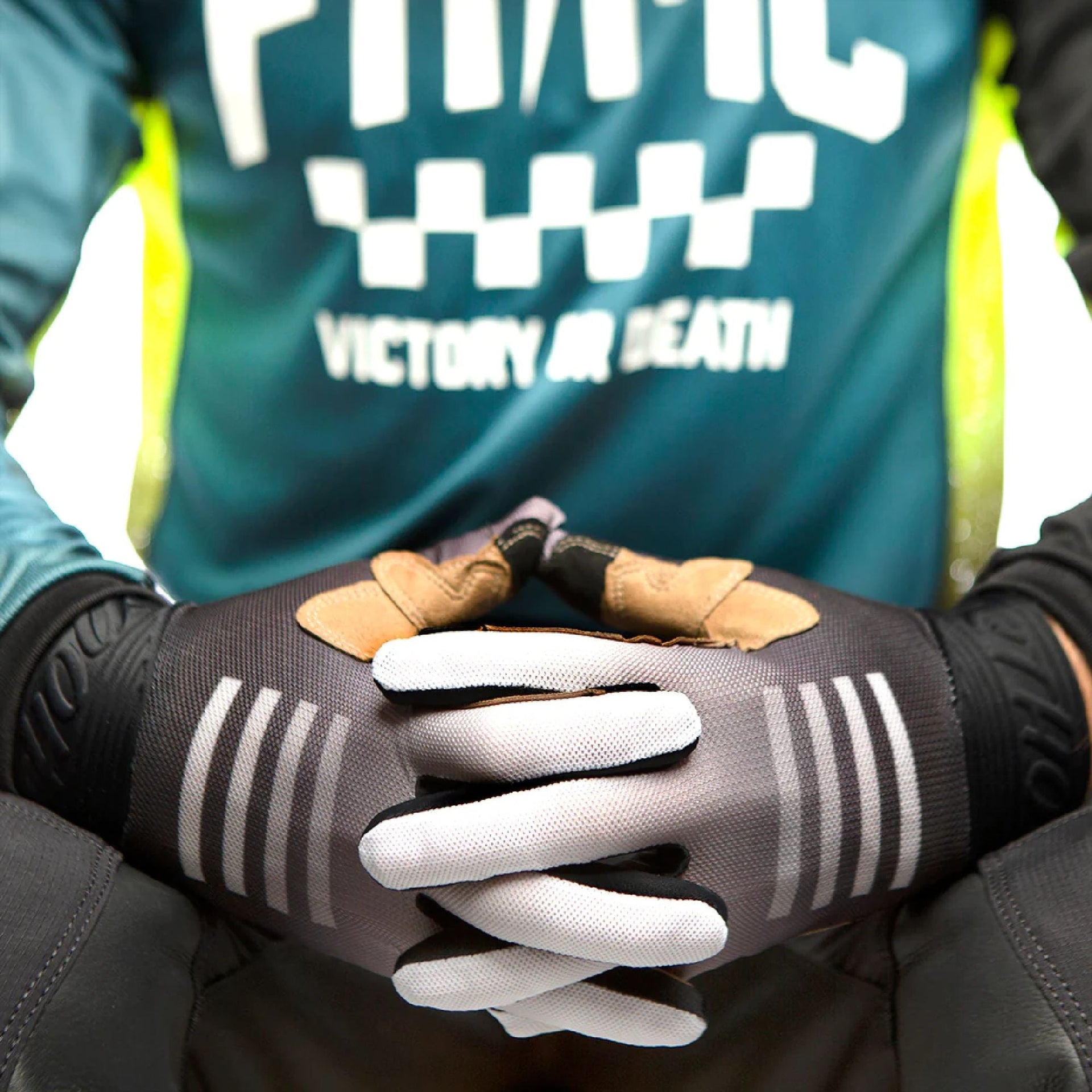 Youth motocross gloves on rider, gray palms with white stripes and black cuffs