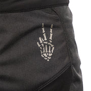 Close-up of dark riding pants with embroidered crest emblem on the thigh