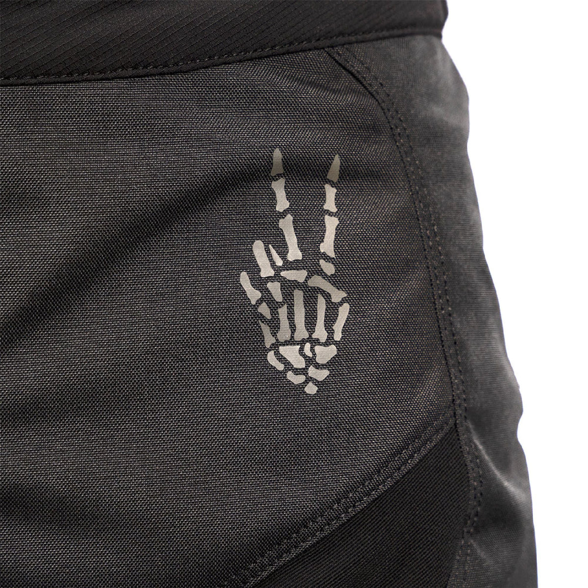 Close-up of dark riding pants with embroidered crest emblem on the thigh