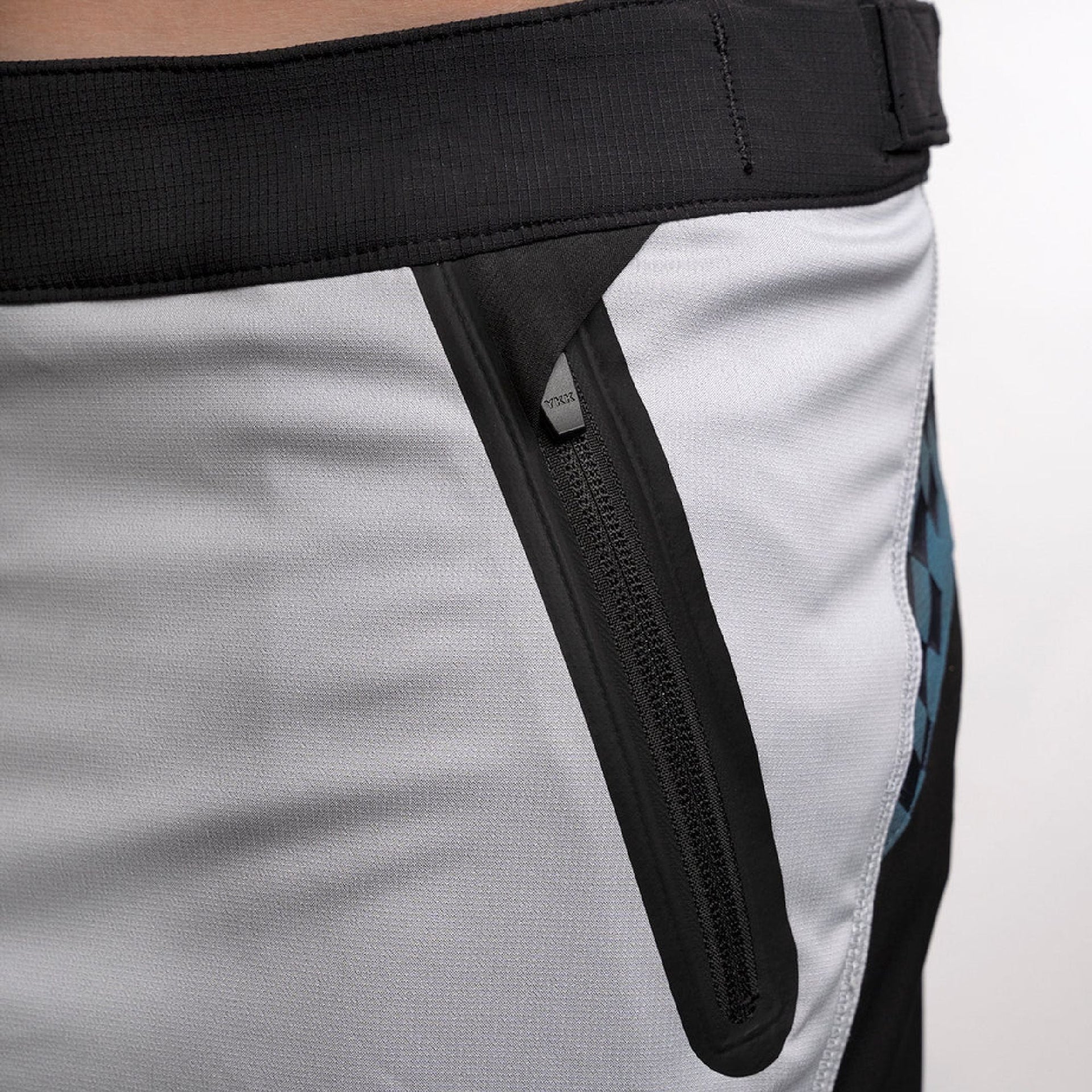 Fasthouse velocity shorts with black zip-style side panel over white fabric