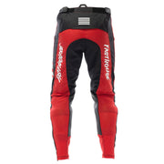 Red and black motocross riding pants with Fasthouse text on legs and reflective stripes.