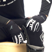 Black motocross air glove with white branding, padded knuckles, and wrist strap