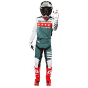 Rider wearing white-and-teal cycling jersey with red star stripe across chest.