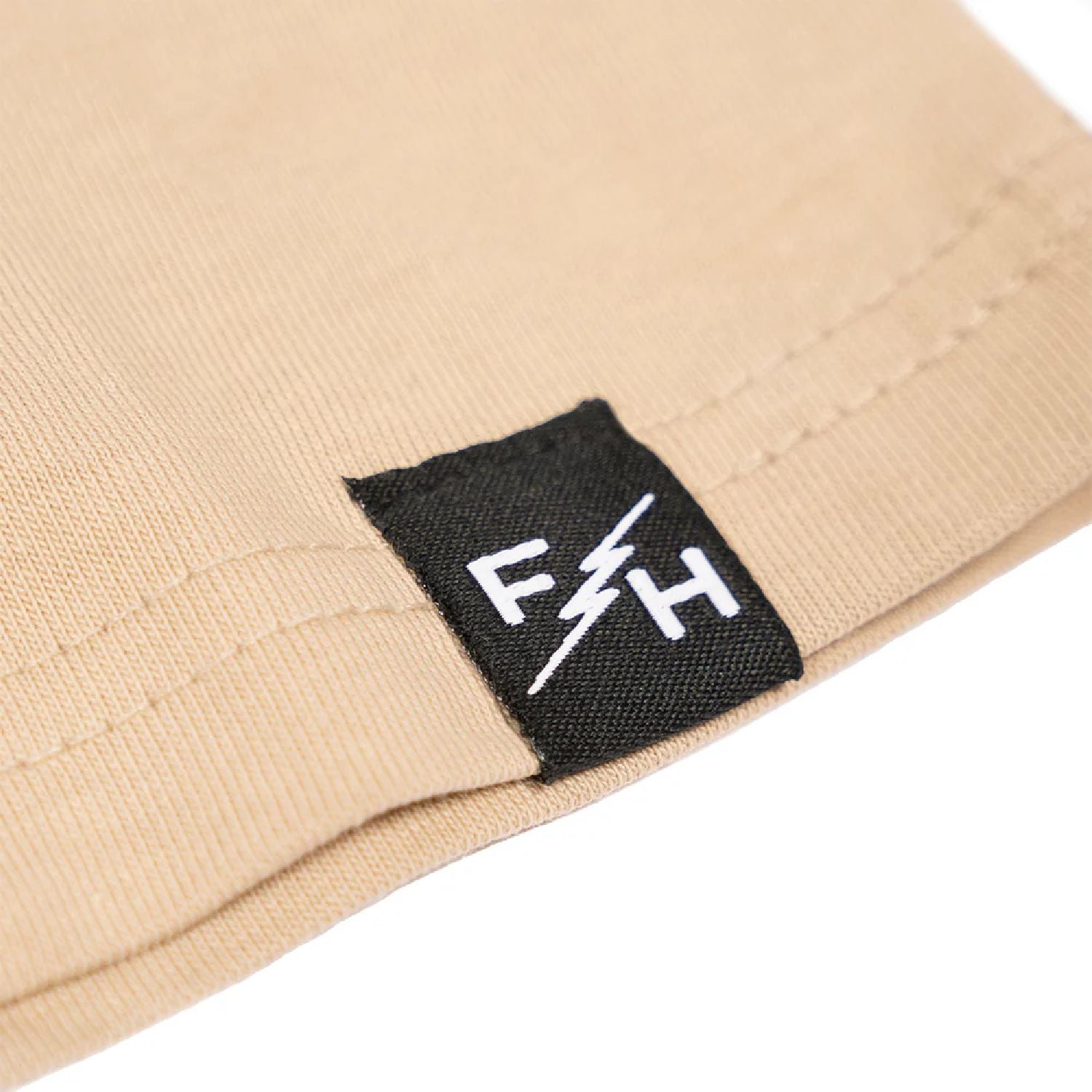Cream long-sleeve cuff with black F&H logo label patch