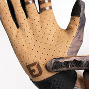 Gray-speckled glove palm close-up with Fasthouse badge and black wrist panel