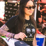 Women's black short-sleeve tee with centered palm-and-logo graphic front print