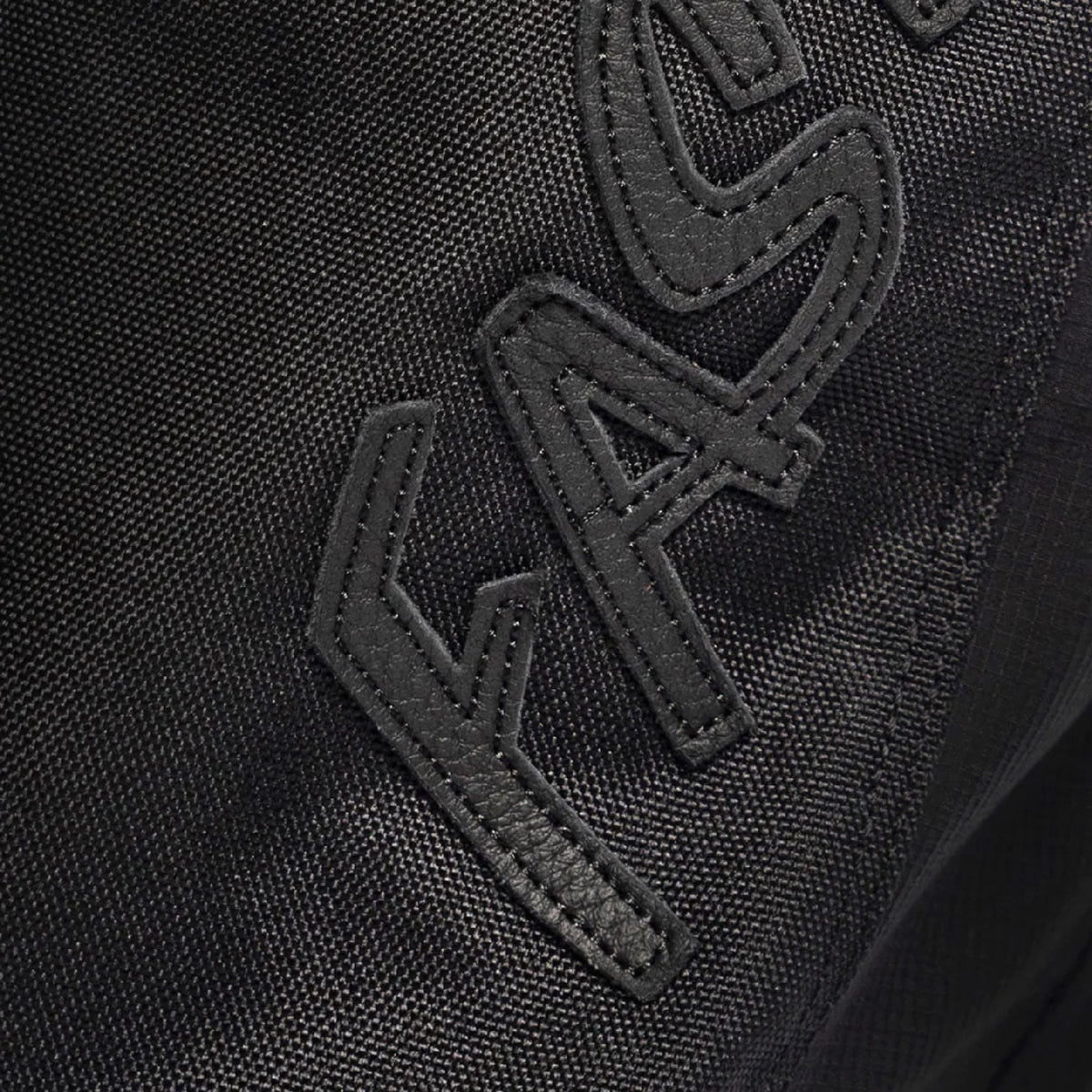 Fasthouse Growler pant fabric close-up, black with stitched logo panel detail