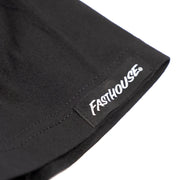 Black short-sleeve tee with Fasthouse logo tag at hem