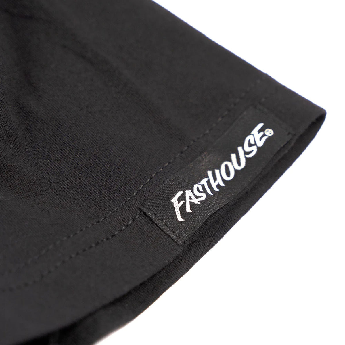 Black short-sleeve tee with Fasthouse logo tag at hem