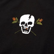 Black T-shirt close-up of white skull lightning graphic with orange and green leaves