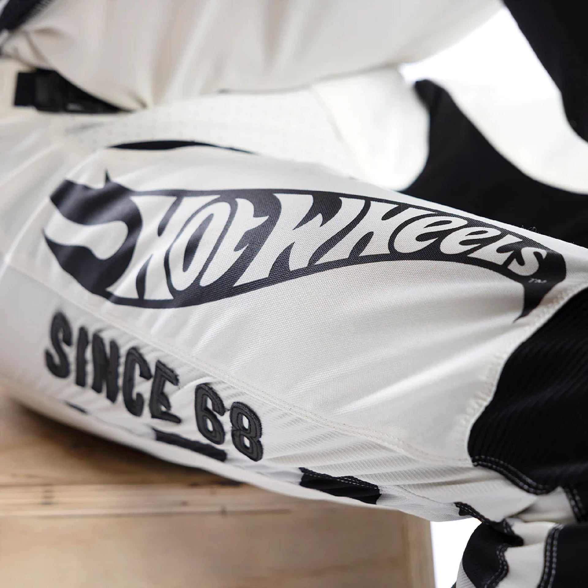 Fasthouse Hot Wheels pant leg close-up with 'Hot Wheels' stripe and 'Since 68'