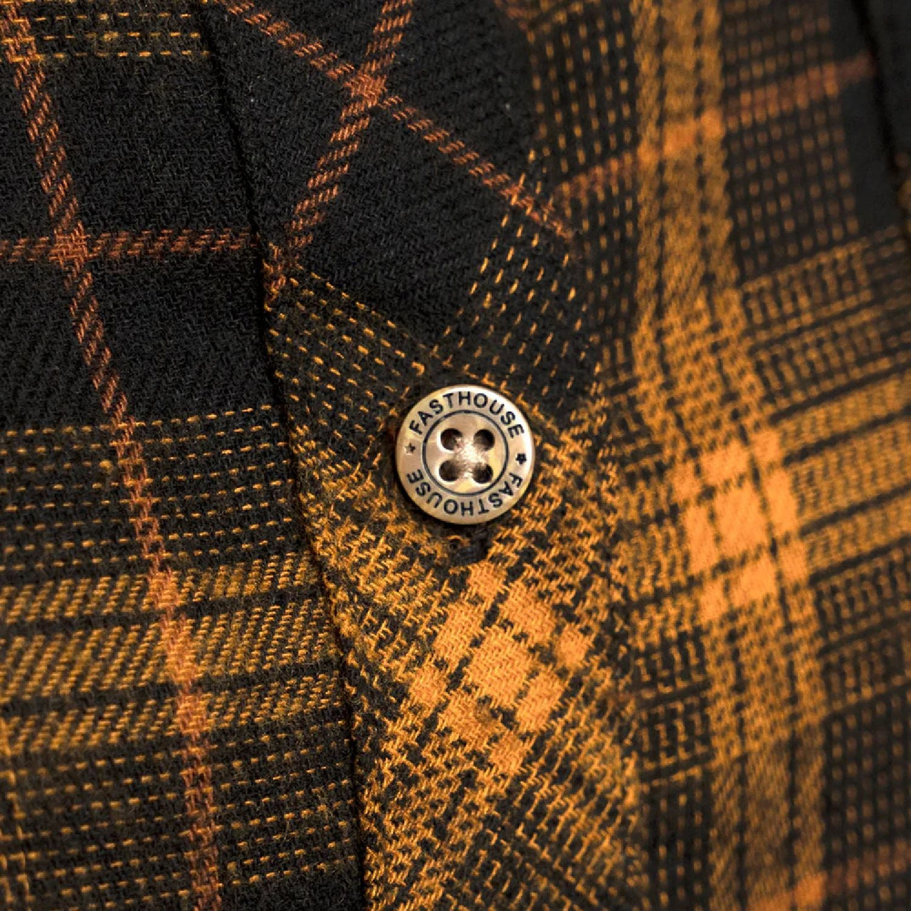 Round brand patch on orange-and-black plaid flannel fabric