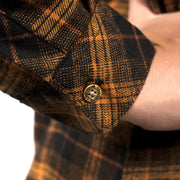 Orange-and-black plaid flannel sleeve cuff with button and stitched detail