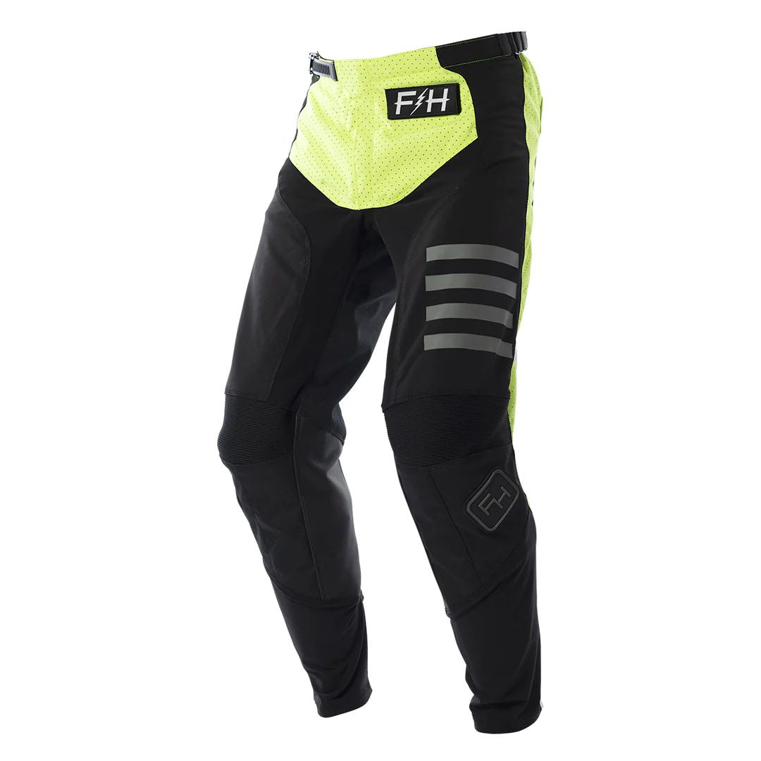 Black motocross pants with hi-viz yellow panels, gray stripes, and F4H logo patch