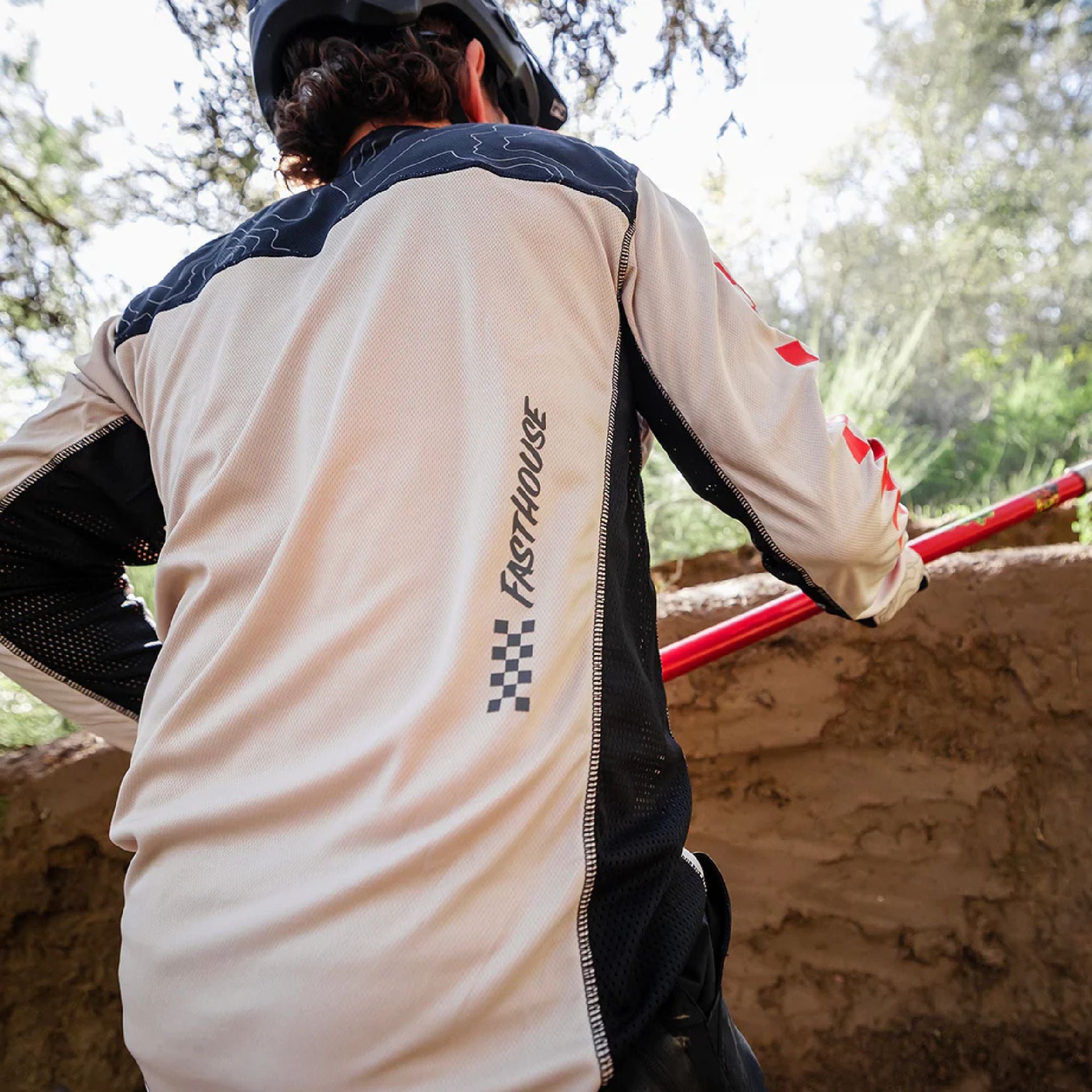 Cream long-sleeve cycling jersey back with black panels and red check accents