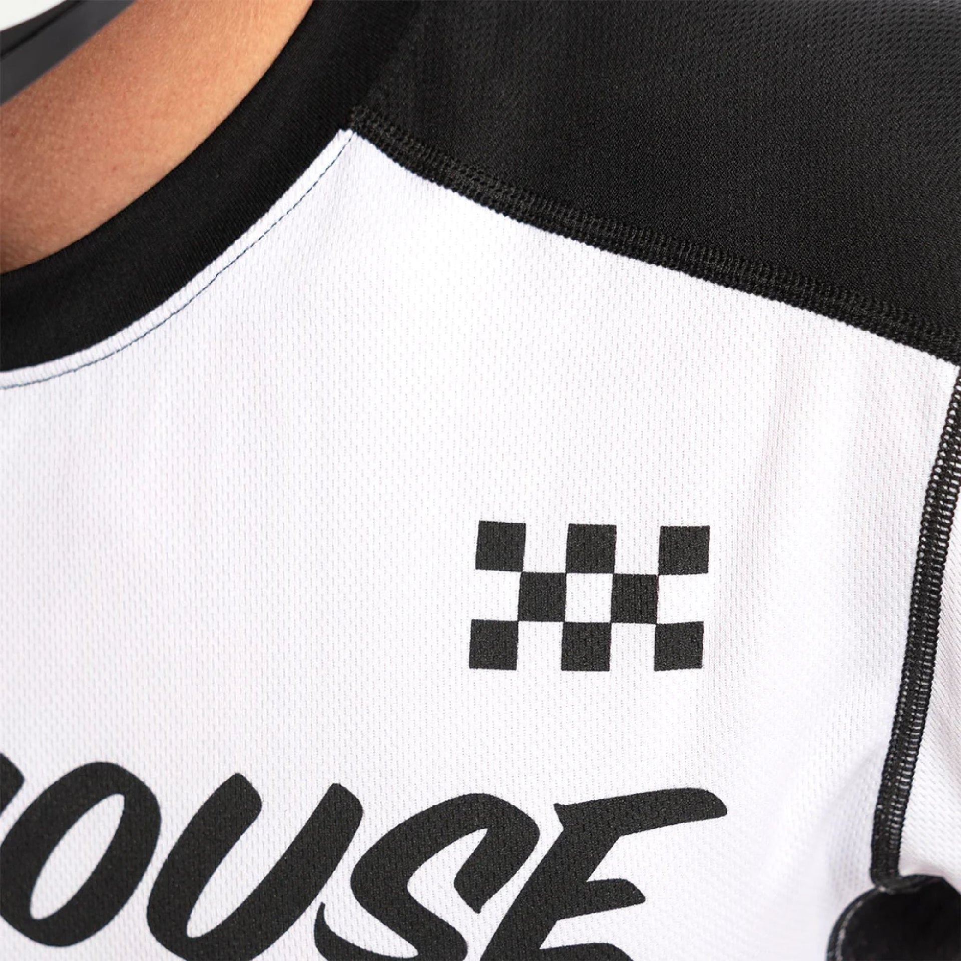 Youth motocross jersey shoulder close-up, black and white with checker patch logo