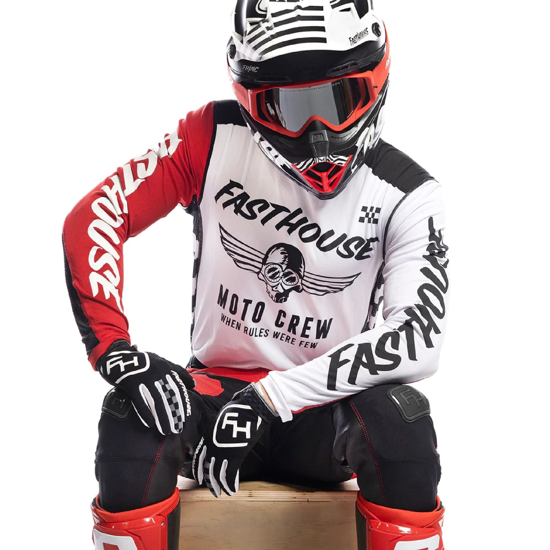Motorcycle jersey with white front, red and black sleeves, bold winged skull logo.