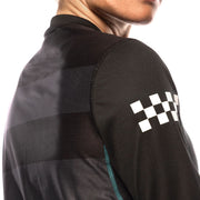 Black long-sleeve riding jersey sleeve detail with white checkered logo