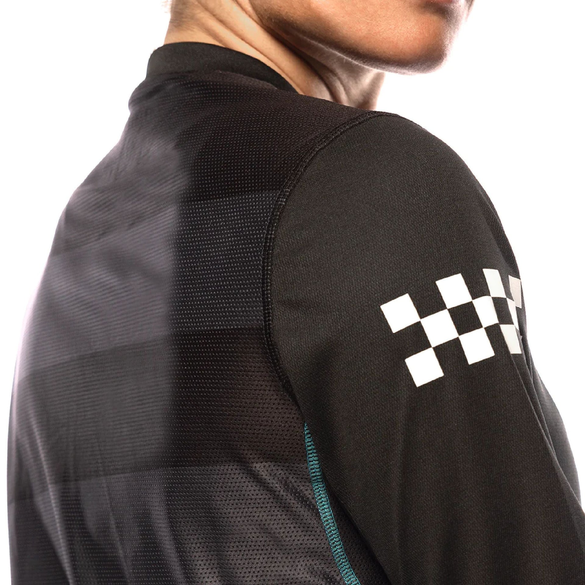 Black long-sleeve riding jersey sleeve detail with white checkered logo