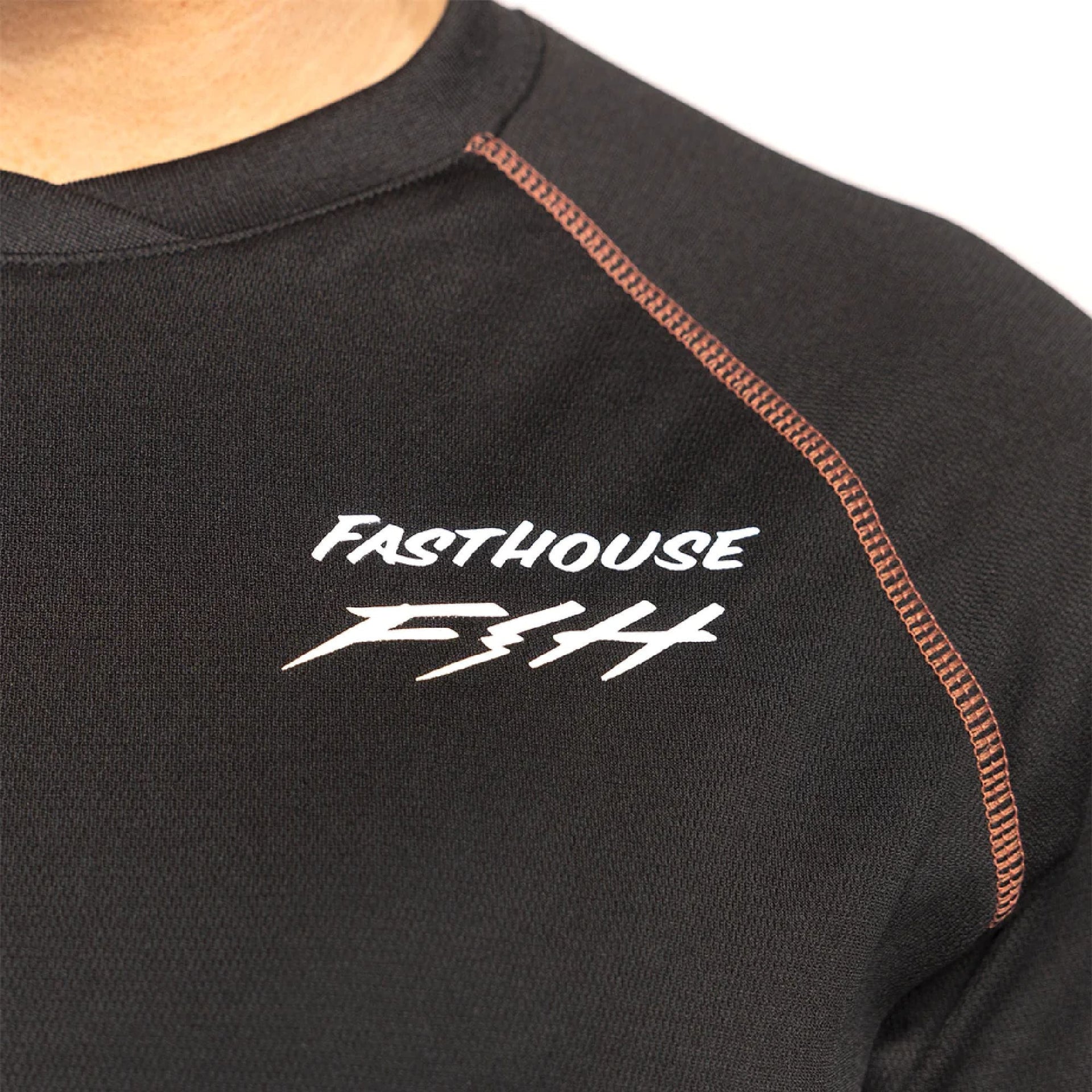 Fasthouse Sidewinder jersey logo on black raglan neck with orange contrast seam.