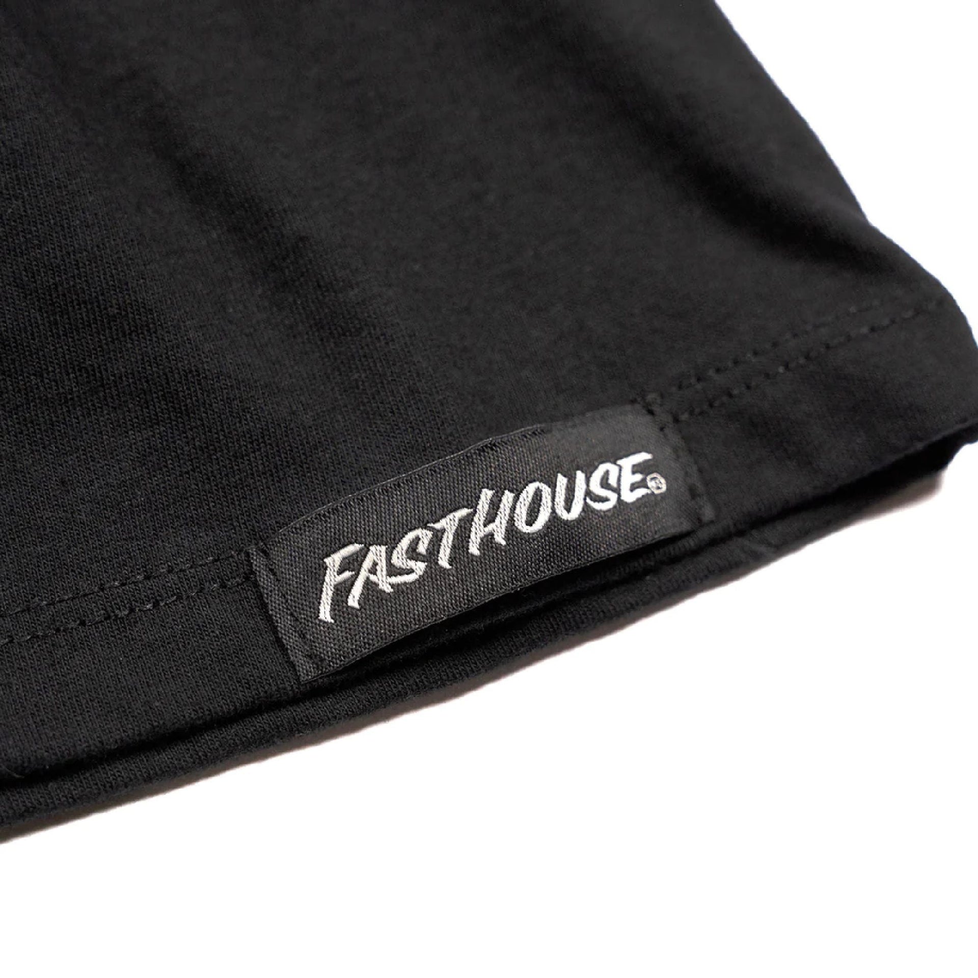Women’s black T-shirt hem with stitched edge and Fasthouse logo patch
