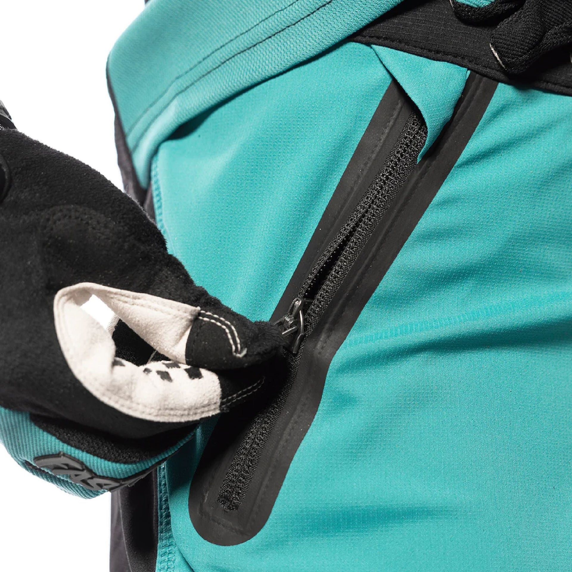 Teal riding shorts with black zipper pocket and pull tab